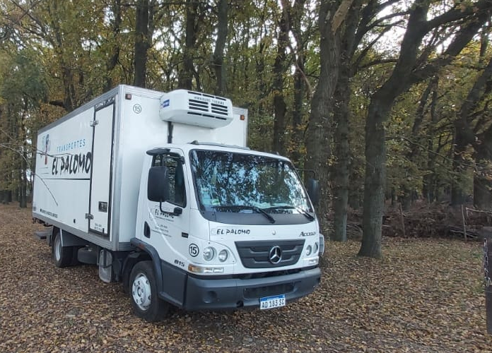 un camion de la empresa pasando por un bosque.